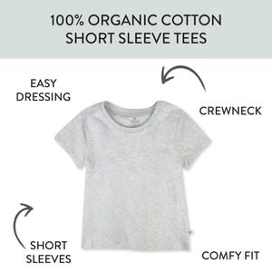 Op de afbeelding: Een lichtgrijs t-shirt met korte mouwen gemaakt van 100% biologisch katoen. Het shirt heeft een ronde hals, korte mouwen en een effen ontwerp. Tekst op de afbeelding bevat 100% ORGANIC COTTON SHORT SLEEVE TEES, EASY DRESSING, CREWNECK, SHORT SLEEVES, COMFY FIT.