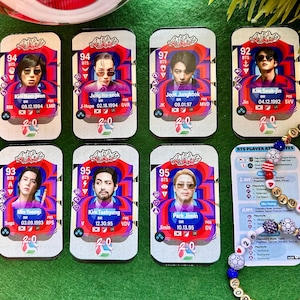 Könnte beinhalten: Sieben rechteckige Sammelkarten mit Porträts der BTS-Mitglieder vor einem wirbelnden rot-blauen Hintergrund, Spielerstatistiken und den Namen Kim Nam-joon, Jung Ho-seok, Jeon Jungkook, Kim Seok-jin, Min Yoongi, Kim Taehyung und Park Jimin.