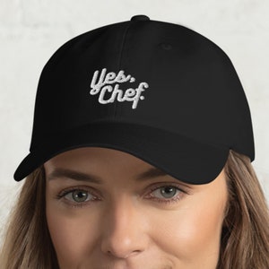 May include: A black baseball cap with white embroidered text that reads "Yes, Chef."
