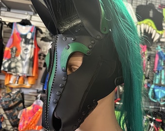 May include: Black leather horse mask with green accents and a green and black mane. The mask has a muzzle and a nose hole.