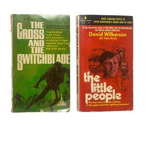 May include: Two paperback books with green and red covers. The book on the left is titled "The Cross and the Switchblade" and features a silhouette of a person holding a knife in front of a city skyline. The book on the right is titled "The Little People" and features a photo of a group of children with a man standing in front of them.