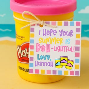 May include: A yellow Play-Doh modeling compound container with a pink lid, tied with twine, and a gift tag. The tag reads "I Hope Your Summer Is DOH-Lightful! Love, Hannah" with colorful text and illustrations.
