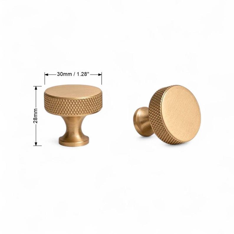 Detailed view of solid brass gold knobs – minimalist furniture hardware on white background.