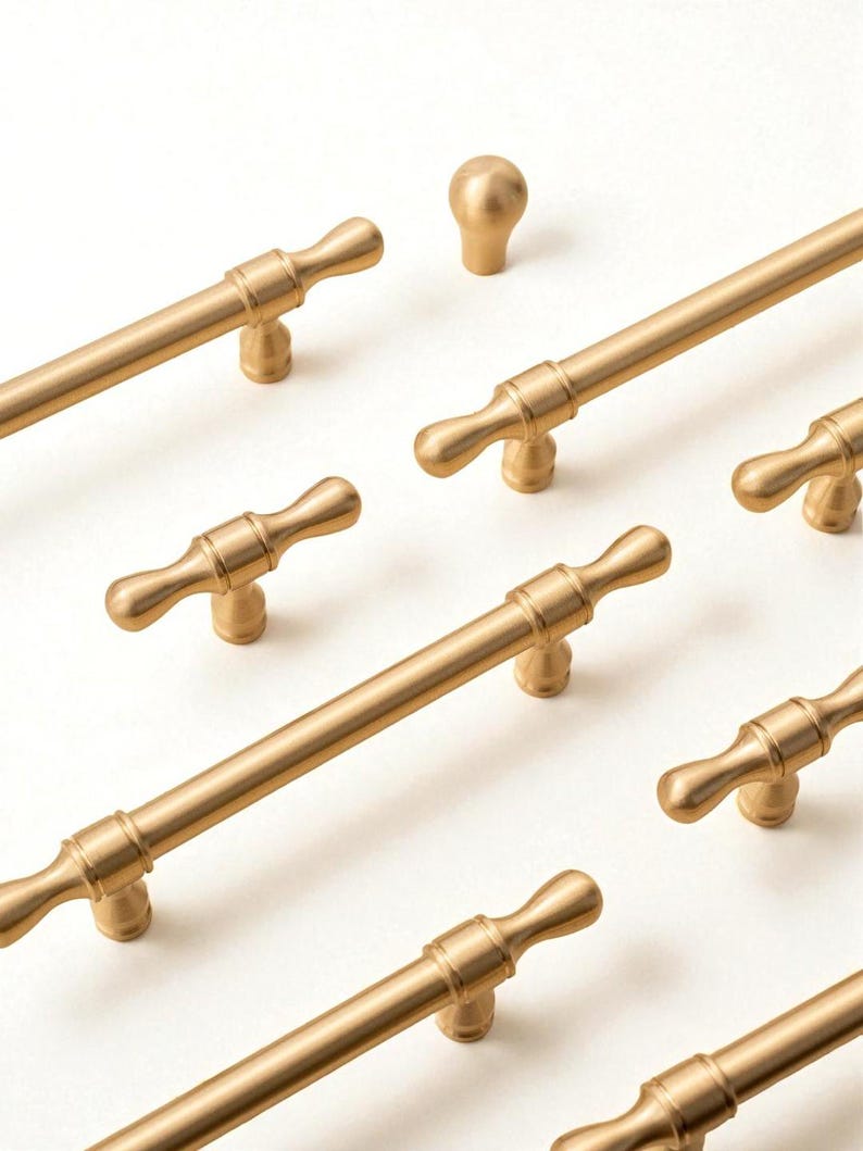 Solid brass handles and knobs – brushed gold modern minimalist cabinet hardware set on white background.