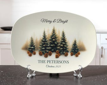 May include: An oval serving platter with a winter forest scene and the text "Merry & Bright." The platter features pine trees, pine cones, and the family name "The Petersons" with the year "Christmas 2025."