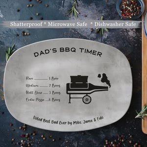 May include: A gray ceramic serving platter with the text "DAD'S BBQ TIMER" and a grill with smoke coming out of it. The platter has a scale for cooking meat with the text "Rare", "Medium", "Well Done", and "Order Pizza" with the corresponding number of beers. The text "Voted Best Dad Ever by Mike, Jamie & Fido" is at the bottom of the platter.