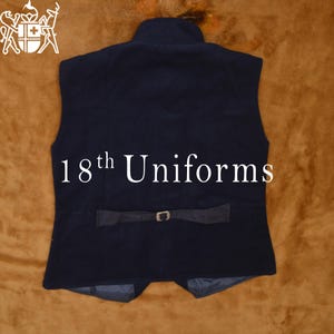 May include: A dark blue vest with a high collar and a belt with a silver buckle. The vest has a label that says "18th Uniforms".