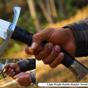 Puede incluir: Una espada de doble filo de plata con empu&ntilde;adura de cuero negro. La espada tiene una punta puntiaguda y una guarda curva. La espada est&aacute; sostenida por la mano de una persona, con la hoja apuntando hacia la c&aacute;mara. El texto "Light Weight Double Handed Sword" es visible en la parte inferior de la imagen.