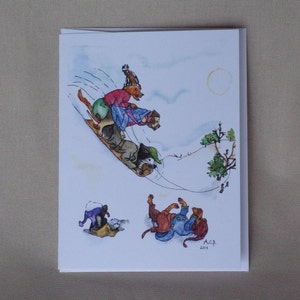 Three dogs are perched on a toboggan sled which is flying down a steep hill.  You can see treetops and other sledders at the bottom. It is a pale sunny day.  Two other dogs are stuck in the drifts and rolling around.  All wear scarves and funny caps.