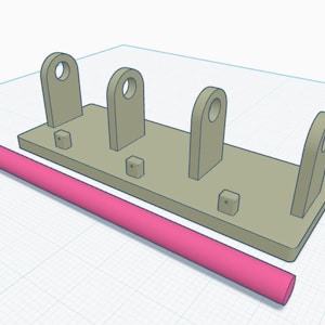 May include: A light tan rectangular base with three upright supports, each with a circular hole at the top. A pink cylindrical rod rests alongside the base. The design appears to be a 3D model.
