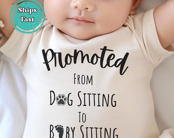 May include: A beige baby onesie with the text "Promoted From Dog Sitting To Baby Sitting" in black. The onesie has a paw print and footprint graphic. A baby is wearing the onesie.