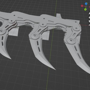 Puede incluir: Un modelo 3D de un arma de m&uacute;ltiples hojas de color plateado con un mecanismo complejo. El arma tiene cuatro hojas, cada una con una punta curva y puntiaguda. Las hojas est&aacute;n conectadas por una serie de bisagras y engranajes, lo que les permite moverse de forma independiente.