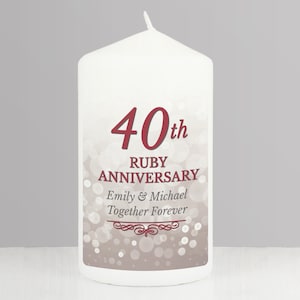 Könnte beinhalten: Eine weiße Kerze mit einem beige-weißen, glitzernden Hintergrund. Die Kerze trägt den Text "40. Rubin-Jubiläum" und "Emily & Michael Together Forever" in rot.