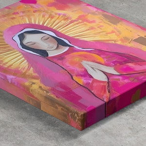 May include: A painting of a woman with her hands clasped in prayer. She is wearing a pink robe with a white halo around her head. The background is a mix of pink, orange, and yellow.