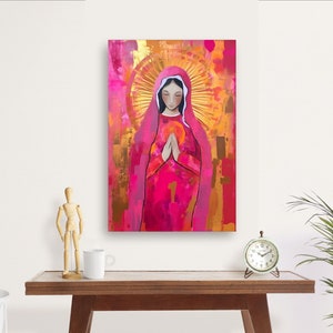 May include: A painting of a woman in a pink robe with her hands clasped in prayer. She is surrounded by a golden halo and a pink and gold background.