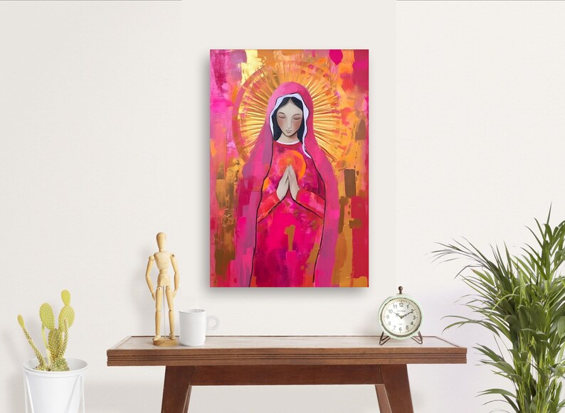 May include: A painting of a woman in a pink robe with her hands clasped in prayer. She is surrounded by a golden halo and a pink and gold background.