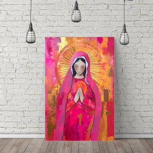 May include: A painting of a woman in a pink robe with a golden halo. She is praying with her hands clasped together. The background is a mix of pink, gold, and white.