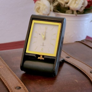 Very pretty travel clock in gold metal, signed Jaeger Lecoultre "and Kirby Beard & Co Paris" Swiss made, mechanical alarm clock.