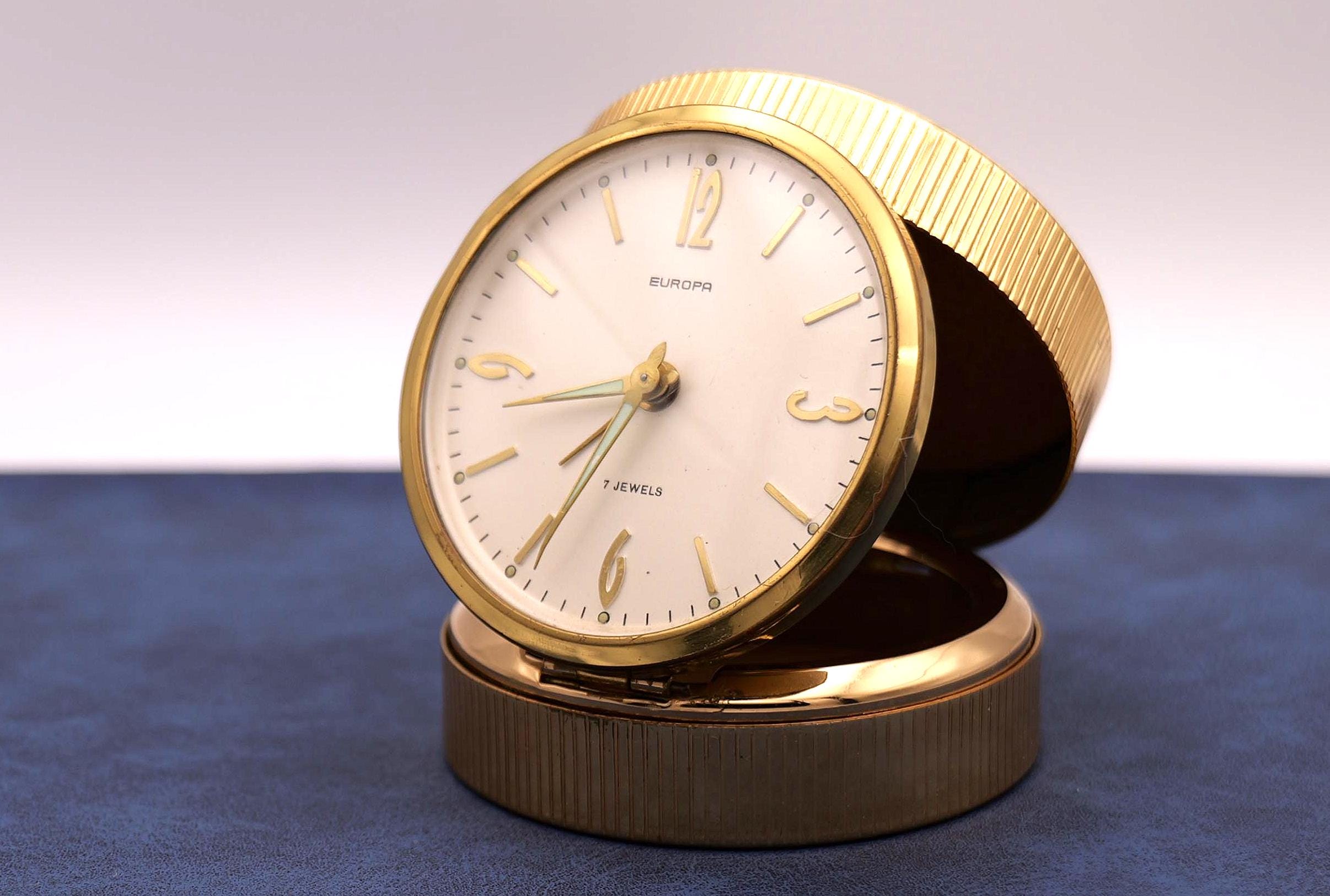 A beautiful little mechanical alarm clock from Europa, in gold. Alarm clock, clock, pendulum.
