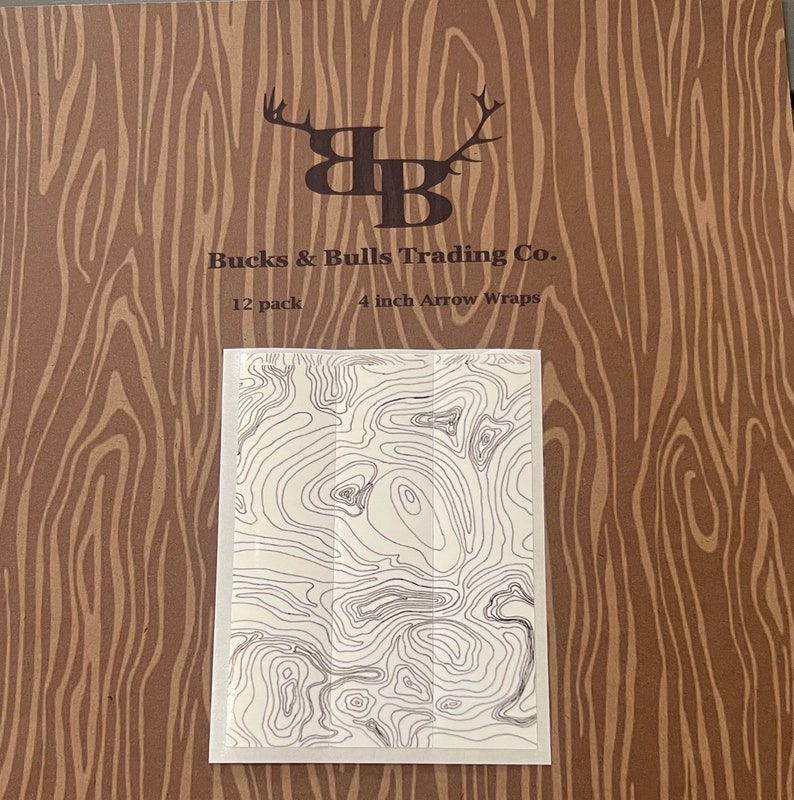 May include: A brown paper background with a black and white logo of a buck and bull head with the text "Bucks & Bulls Trading Co." and "12 pack 4 inch Arrow Wraps". A white rectangle with a black and white topographic map design is in the center of the image.
