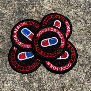 May include: Five round black and red embroidered patches with a white pill design and text that reads "Good for Health, Bad for Education" and "Good for Education, Bad for Health".