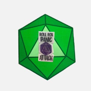 May include: A green twenty-sided die with a sticker that says "Roll for Panic Attack" and a purple die with a one showing.