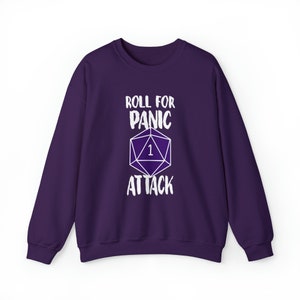 May include: Purple sweatshirt with a white graphic of a dice with the number 1 and the text "Roll for Panic Attack".
