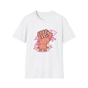 May include: White t-shirt featuring a pink crystal fist graphic and the text "God Lied" in red.