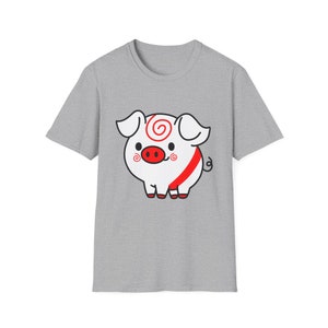 May include: A gray t-shirt with a cartoon pig wearing a red and white striped outfit. The pig has a red nose and a white swirl on its forehead.