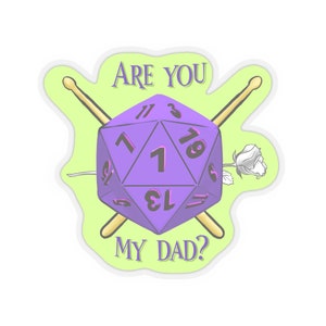 Può includere: Un dado a 20 facce viola con il numero 1 in alto, incrociato da due bacchette di legno e una rosa bianca. Il testo "ARE YOU MY DAD?" è scritto sopra il dado.