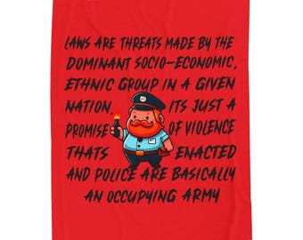 May include: Red blanket with a cartoon illustration of a police officer holding a lit torch. The blanket has black text that reads: "LAWS ARE THREATS MADE BY THE DOMINANT SOCIO-ECONOMIC, ETHNIC GROUP IN A GIVEN NATION..."