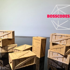 Peut inclure: Un ensemble de huit caisses en bois miniatures, empil&eacute;es et dispos&eacute;es sur une surface noire. Les caisses sont en bois brun clair avec une finition peinte blanche et ont un aspect vieilli. Les caisses sont de tailles et de formes diff&eacute;rentes, et certaines sont empil&eacute;es les unes sur les autres.