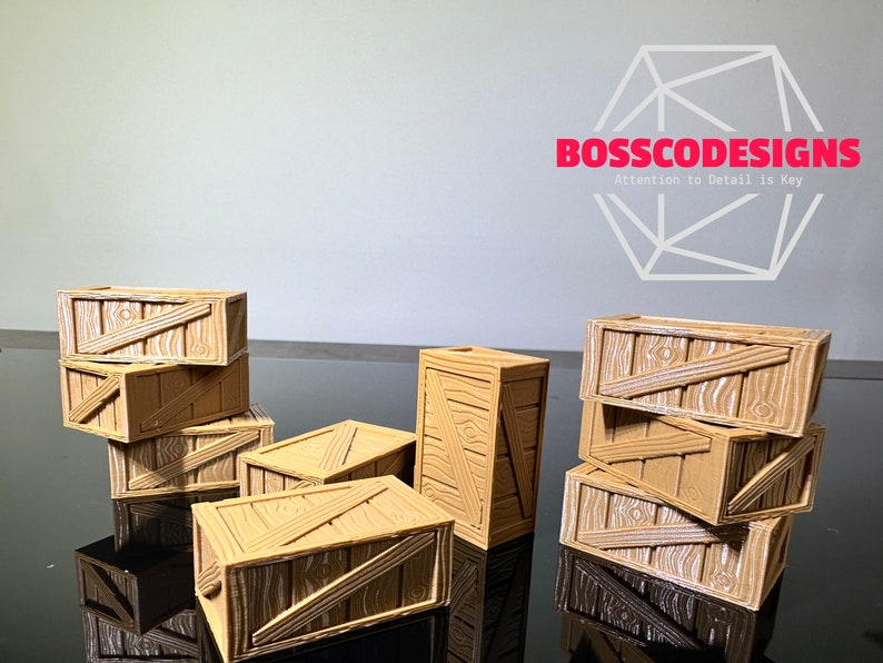 Peut inclure: Un ensemble de huit caisses en bois miniatures, empil&eacute;es et dispos&eacute;es sur une surface noire. Les caisses sont en bois brun clair avec une finition peinte blanche et ont un aspect vieilli. Les caisses sont de tailles et de formes diff&eacute;rentes, et certaines sont empil&eacute;es les unes sur les autres.