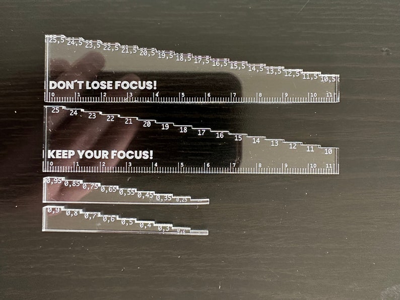 May include: Two clear plastic rulers with black markings and motivational messages. The top ruler reads "DON'T LOSE FOCUS!" and the bottom ruler reads "KEEP YOUR FOCUS!"