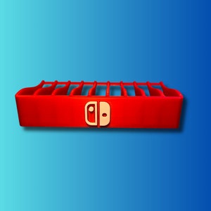 Könnte beinhalten: Roter Plastik-Spielekartuschenhalter mit Steckplätzen für mehrere Kartuschen. Der Halter trägt das Nintendo Switch-Logo auf der Vorderseite.
