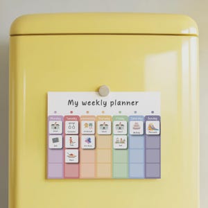 May include: A colorful weekly planner with the text "My weekly planner" and illustrated activity icons. The planner is attached to a yellow surface with a magnet. The days of the week are color-coded.