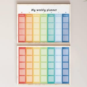 May include: Two wooden-framed weekly planners. Each planner features a rainbow gradient design with sections for each day of the week. The text "My weekly planner" is at the top. The color scheme includes red, orange, yellow, green, blue, and purple.