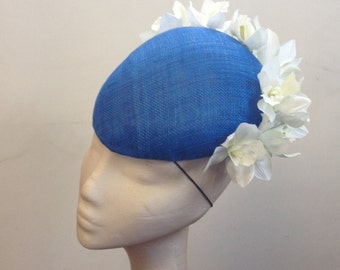 Striking Bright Blue Pointed Beret Hat with White Orchid Flowers to the back edge.