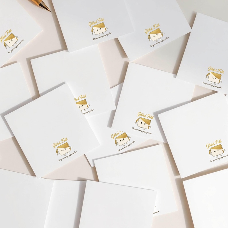 a collection of white square cards or envelopes, each with a gold-colored illustration and text printed on them.