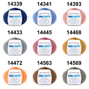 May include: Nine balls of yarn in different colors, including blue, light blue, pink, gray, light pink, yellow, orange, brown, and green. Each ball has a white label with the text "LANA GATTO MADE IN ITALY SUPER SOFT www.lanagatto.it" and a number printed above the label.