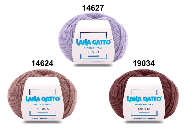 Op de afbeelding: Drie bollen garen in verschillende kleuren: lavendel, lichtroze en bruin. Elke bol heeft een wit etiket met de tekst "LANA GATTO" en "MADE IN ITALY" in blauwe tekst. Het etiket bevat ook de tekst "MISINA" in blauwe tekst. De bollen zijn ge&euml;tiketteerd met de nummers 14627, 14624 en 19034.