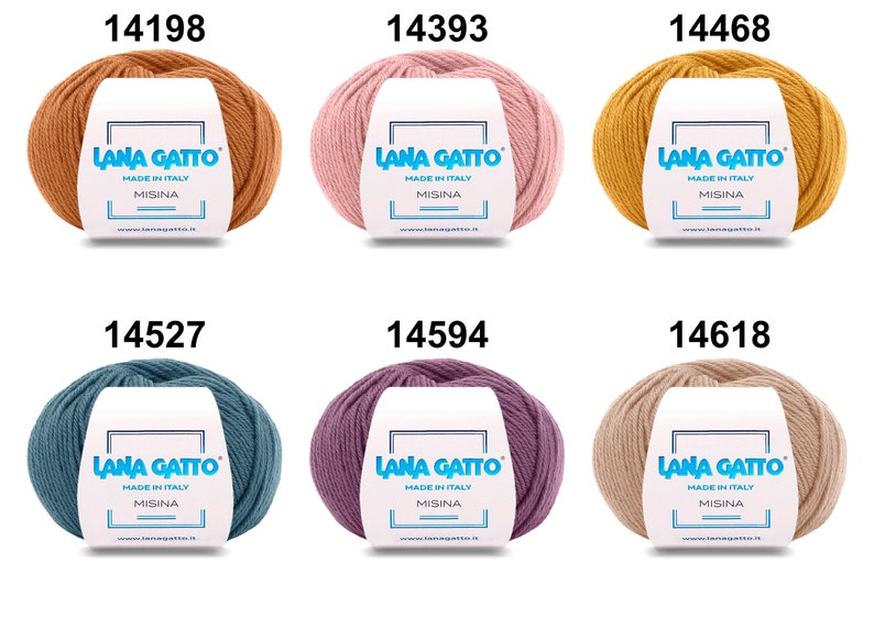 Op de afbeelding: Zes bollen Lana Gatto Misina garen in verschillende kleuren, waaronder oranje, roze, geel, blauw, paars en beige. Elke bol heeft een label met de merknaam en "Made in Italy".
