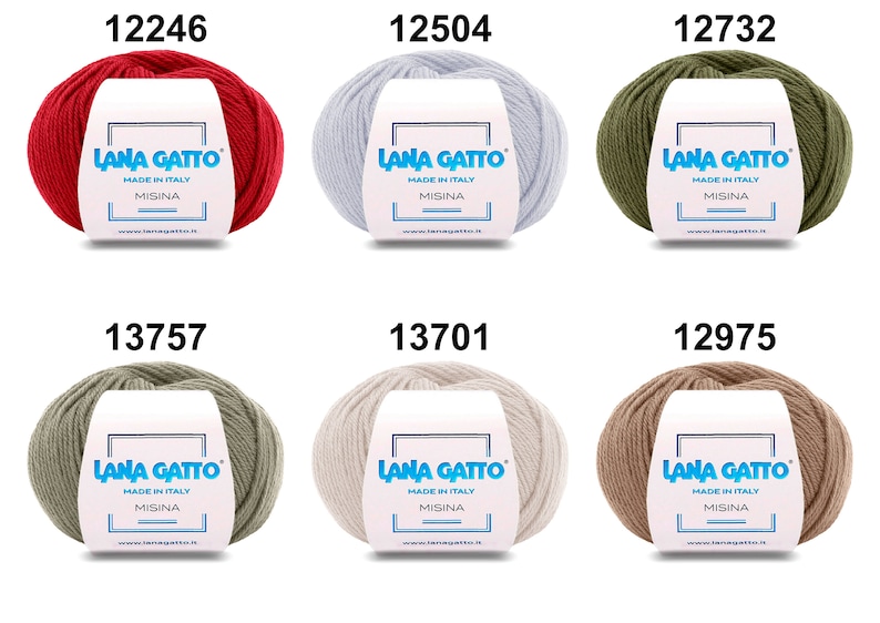 Op de afbeelding: Zes bollen garen in verschillende kleuren, waaronder rood, wit, groen, grijs, beige en bruin. Elke bol heeft een label met de tekst "Lana Gatto" en "Made in Italy".
