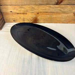 May include: A large, oval-shaped serving platter with a glossy, dark blue glaze.