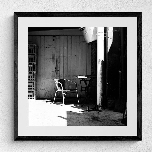 Makeshift break room with table and chairs amongst the milk crates in a cafe side alley, urban industrial photo print, film photography