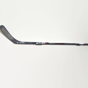 May include: A black and white hockey stick with a red and white Bauer logo and a black CCM logo. The stick is mounted on a white wall.