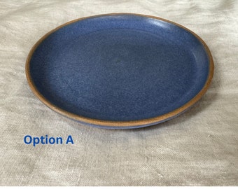 May include: A blue ceramic plate with a brown rim. The plate is on a white linen surface. Option A is written in blue text below the plate.