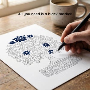 May include: A black marker is used to colour a tree design on white paper. The tree has a floral pattern with dark blue accents. The text "All you need is a black marker" is above the paper. A mug of coffee sits in the background.