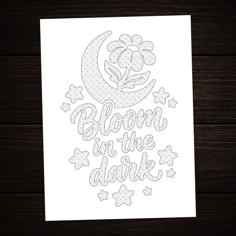 May include: A white coloring page featuring a black line art illustration of a crescent moon, a flower, and several stars. The text "Bloom in the dark" is written in the center in a cursive script font. The entire design has a subtle dot pattern.