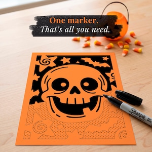 May include: A rectangular coloring sheet featuring a large central skull graphic surrounded by stars and bats. The top portion is filled in with black ink, while the bottom half shows outlines and dot patterns. A black Sharpie marker rests on the paper.